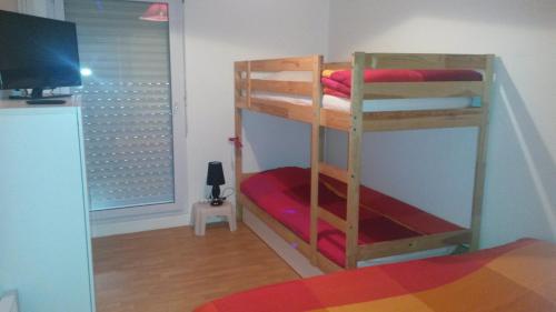 ヴァンヌにあるAppartementの二段ベッド2台、テレビが備わる客室です。