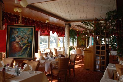 un restaurante con mesas y sillas y una pintura en la pared en Hôtel Le Bellevue Montrichard 3 étoiles en Montrichard