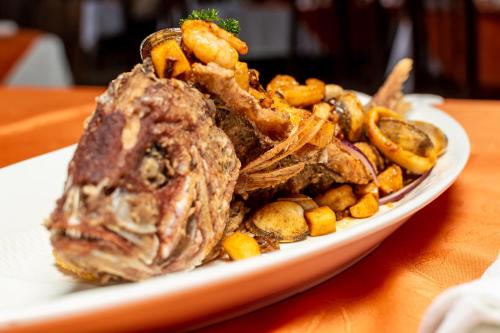 a plate of food with meat and vegetables on a table at Hotel Pacuare in Siquirres