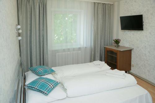 カリーニングラードにあるТрехкомнатная в историческом центреの窓付きの客室で、白いベッド2台が備わります。