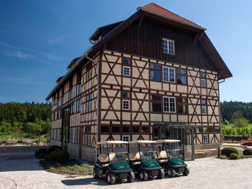 a building with four golf carts parked in front of it at Spa & GolfResort Weimarer Land in Blankenhain