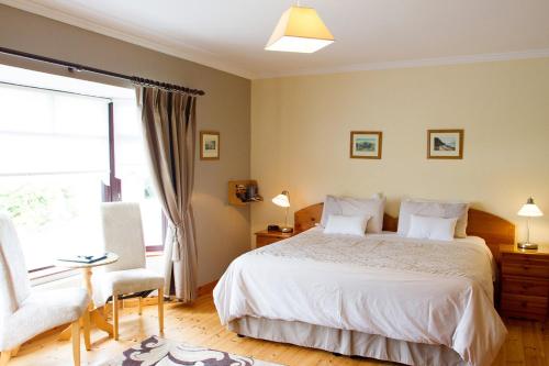 a bedroom with a bed and a chair and a window at Mourneview B & B in Carlingford