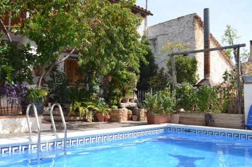 a swimming pool in front of a house with plants at Casas Rurales La Tejeruela in Yeste