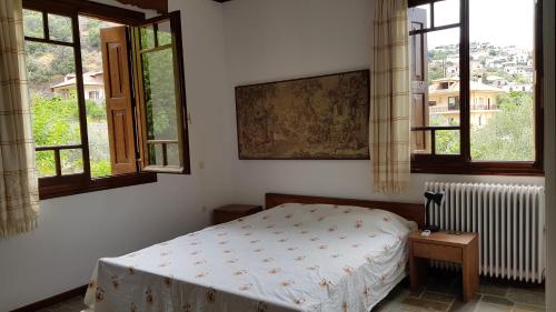 ネア・エピダヴロスにあるAmple Modern Country Homeのベッドルーム1室(ベッド1台、窓2つ付)