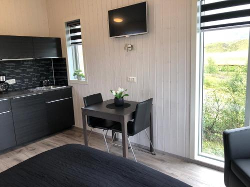 a bedroom with a table with chairs and a kitchen at Afternoon Cottages in Hella
