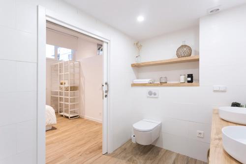 a white bathroom with a toilet and a sink at GETARIA APARTAMENTUAK - Sahatsaga in Getaria