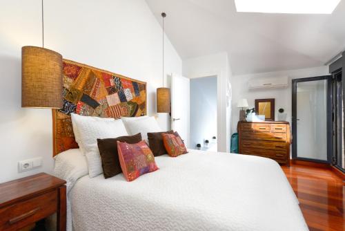 a bedroom with a large white bed with colorful pillows at Boutique Penhouse in the City Old Town in Alicante