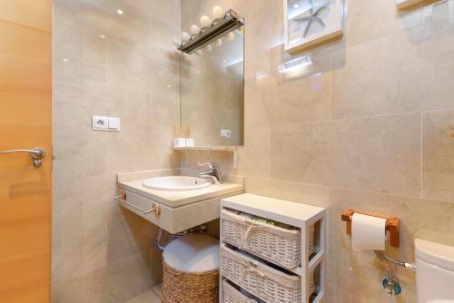 a bathroom with a sink and a toilet and a mirror at Boutique Penhouse in the City Old Town in Alicante
