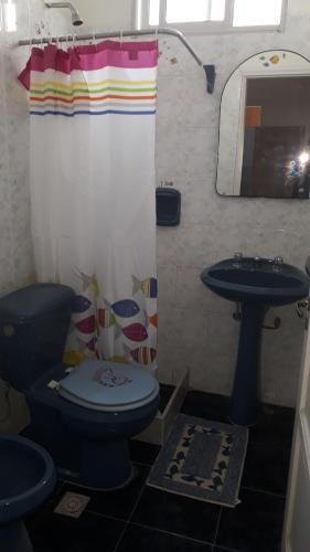 a bathroom with a blue toilet and a sink at Casa del Mar in Montevideo