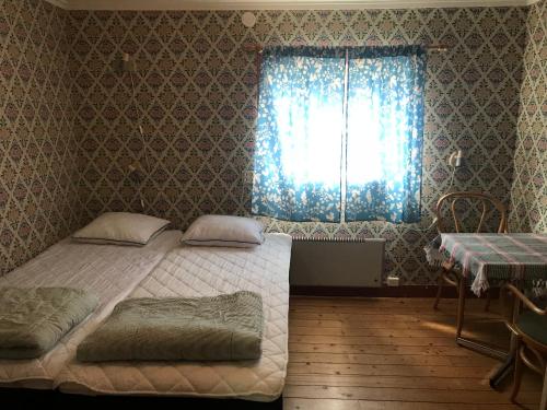 a bedroom with two twin beds and a window at Annexet Gästgivaregården Sunne in Sunne