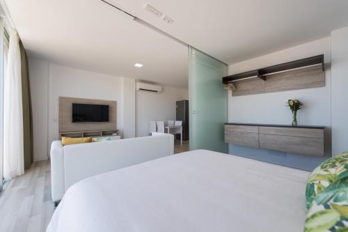 a bedroom with a white bed and a television at Beyond Amadores by Vector in Mogán