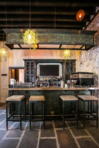 a bar with stools in a room with a counter at Casona de los Sapos Hotel Boutique in Puebla