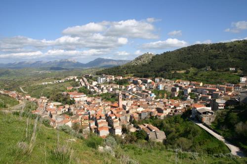 a small town on a hill with mountains in the background at Hotel Su Lithu in Bitti