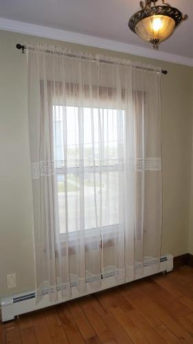 a large window with white curtains in a room at Inn on the Harbour in Charlottetown