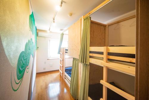 a room with two bunk beds and a window at Hostel KIKO in Sendai