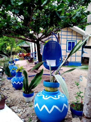 a row of blue vases with plants in front of a house at Bolo Beach Santorini nearby to Hundred Island in Alaminos