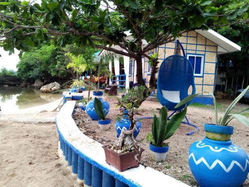 a row of blue vases with plants in front of a house at Bolo Beach Santorini nearby to Hundred Island in Alaminos