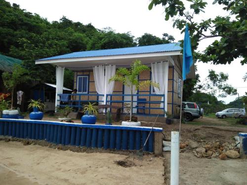 a small house with a blue fence in front of it at Bolo Beach Santorini nearby to Hundred Island in Alaminos