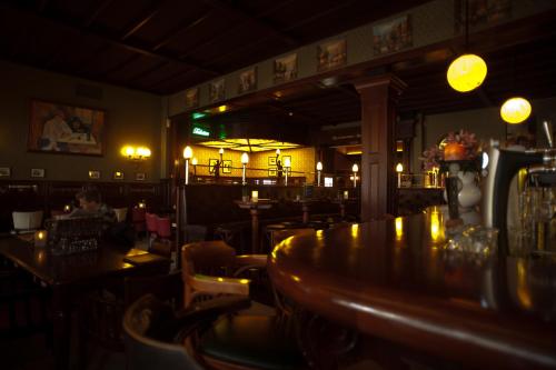 a bar with a wooden table in a restaurant at Hotel et le Cafe de Paris in Apeldoorn