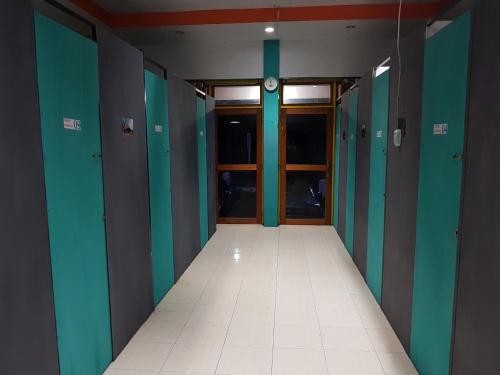 an empty hallway with green and blue walls and a door at Dasi Guesthouse in Ende