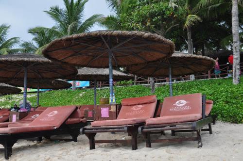 two beach chairs and umbrellas on a beach at Sanya Yikehai View Apartments in Sanya
