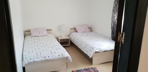 1 dormitorio con 2 camas y puerta abierta en Sweet home en Kenitra