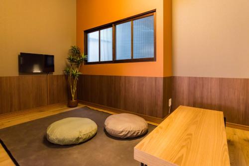 a room with two ottomans and a table and a window at Bijou Suites Musubi in Osaka
