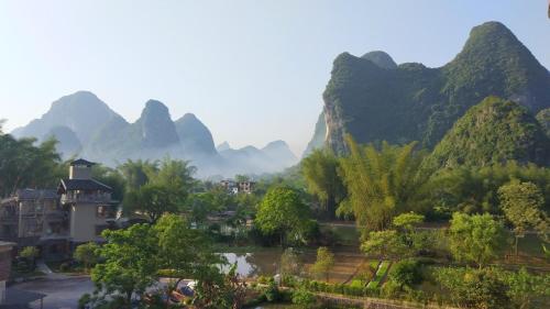 a view of a village with mountains in the background at The Apsara Lodge-Airport or TS Free pick-up over 3 nights in Yangshuo