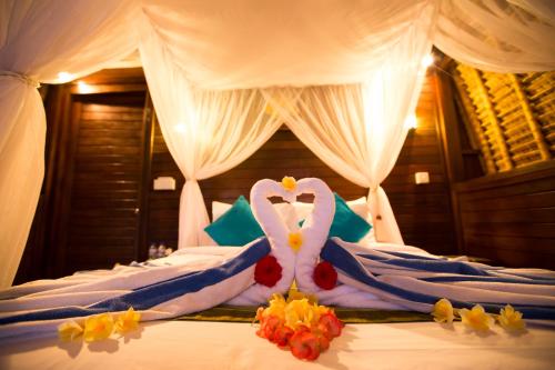 a bed with a swan made out of flowers on it at D'Coin Lembongan in Nusa Lembongan