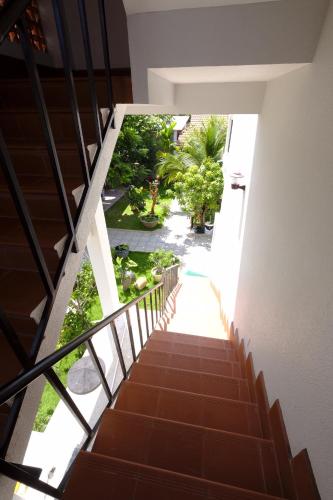 a stairway leading up to a building with trees at MAY Bungalow in Mui Ne