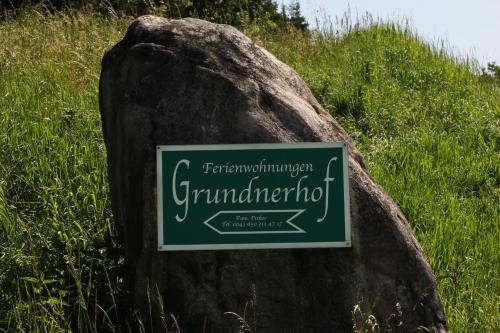 a sign on a rock in a field of grass at Grundnerhof in Arriach