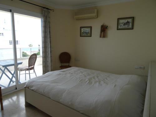 een slaapkamer met een bed en een balkon met een tafel bij Residencia Pez Espada in Torremolinos