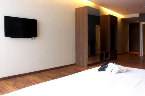 a bedroom with a bed with a tv on the wall at Imperial Regency Suites & Petaling Jaya in Kuala Lumpur