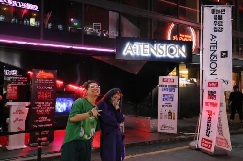 a man and a woman standing under a street sign at Zibro S in Seoul