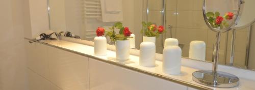 a bathroom counter with white candles and flowers on it at Tor zum Meer in Helgoland
