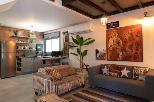 a living room with a couch and a refrigerator at Inspirational Apartment in Tel Aviv