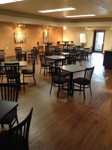 a dining room with tables and chairs and wooden floors at FairBridge Extended Stay, a Kitchenette Hotel in Idaho Falls