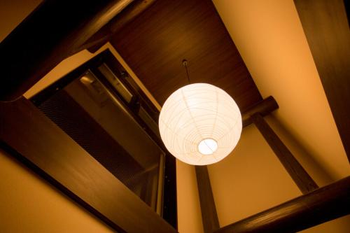 a white lantern hanging from a stairway at Kyoto Takasegawa Bettei in Kyoto