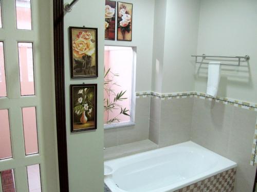 ein Badezimmer mit einer Badewanne und Bildern an der Wand in der Unterkunft Venezia Suites Resort Panglao in Panglao