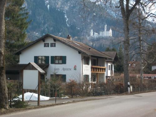 a white house on the side of a road at Haus Alpenrose in Schwangau
