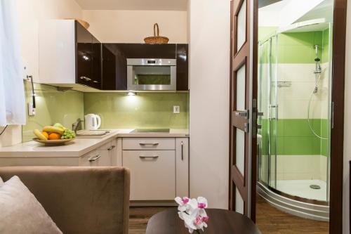 a kitchen with green and white cabinets and a table at Apartament Krupowki CENTRUM in Zakopane