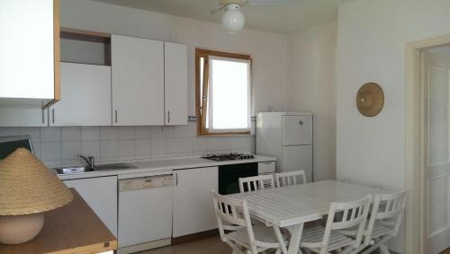eine Küche mit einem Tisch und einem weißen Kühlschrank in der Unterkunft Villetta Cinquale Versilia in Cinquale