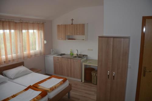 a small bedroom with a bed and a kitchen at Pansion Ivan in Međugorje