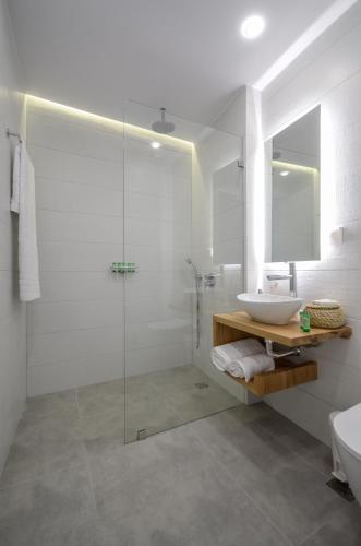 a bathroom with a glass shower and a sink at 3 Wishes in Naxos Chora