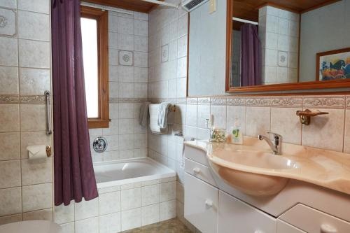 a bathroom with a sink, toilet, and bathtub at Admiral Court Motel & Apartments in Invercargill