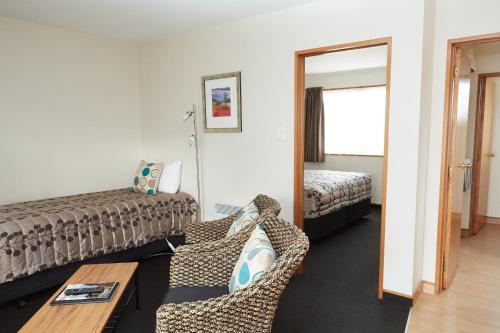 a hotel room with a couch and a bed at Admiral Court Motel & Apartments in Invercargill