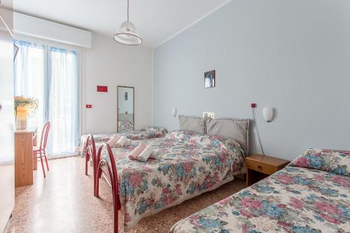 a bedroom with two beds and a table and chairs at Holiday in Milano Marittima