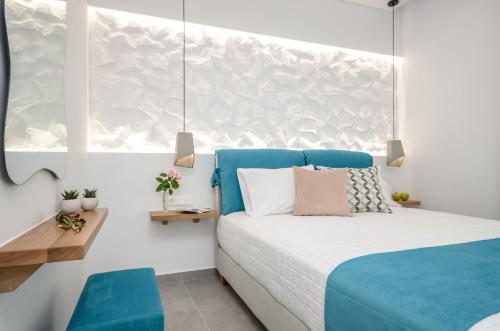 a bedroom with a blue and white bed and a window at 3 Wishes in Naxos Chora