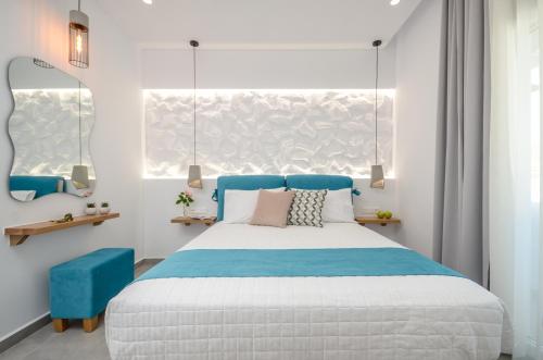 a bedroom with a blue and white bed and a window at 3 Wishes in Naxos Chora