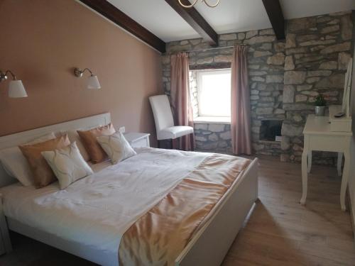 a bedroom with a bed and a stone wall at Tailor's house in Labin